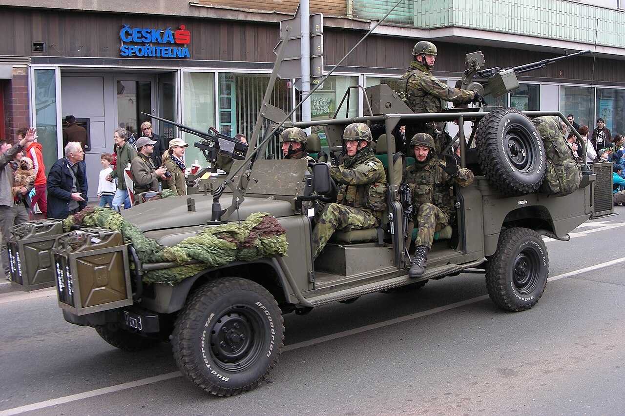A Czech Army Defender 130 Kajman with ring-mounted heavy machine gun and front jerry-can carriers on parade in Plzeň, 2015 — the SVOS conversion built at Přelouč.