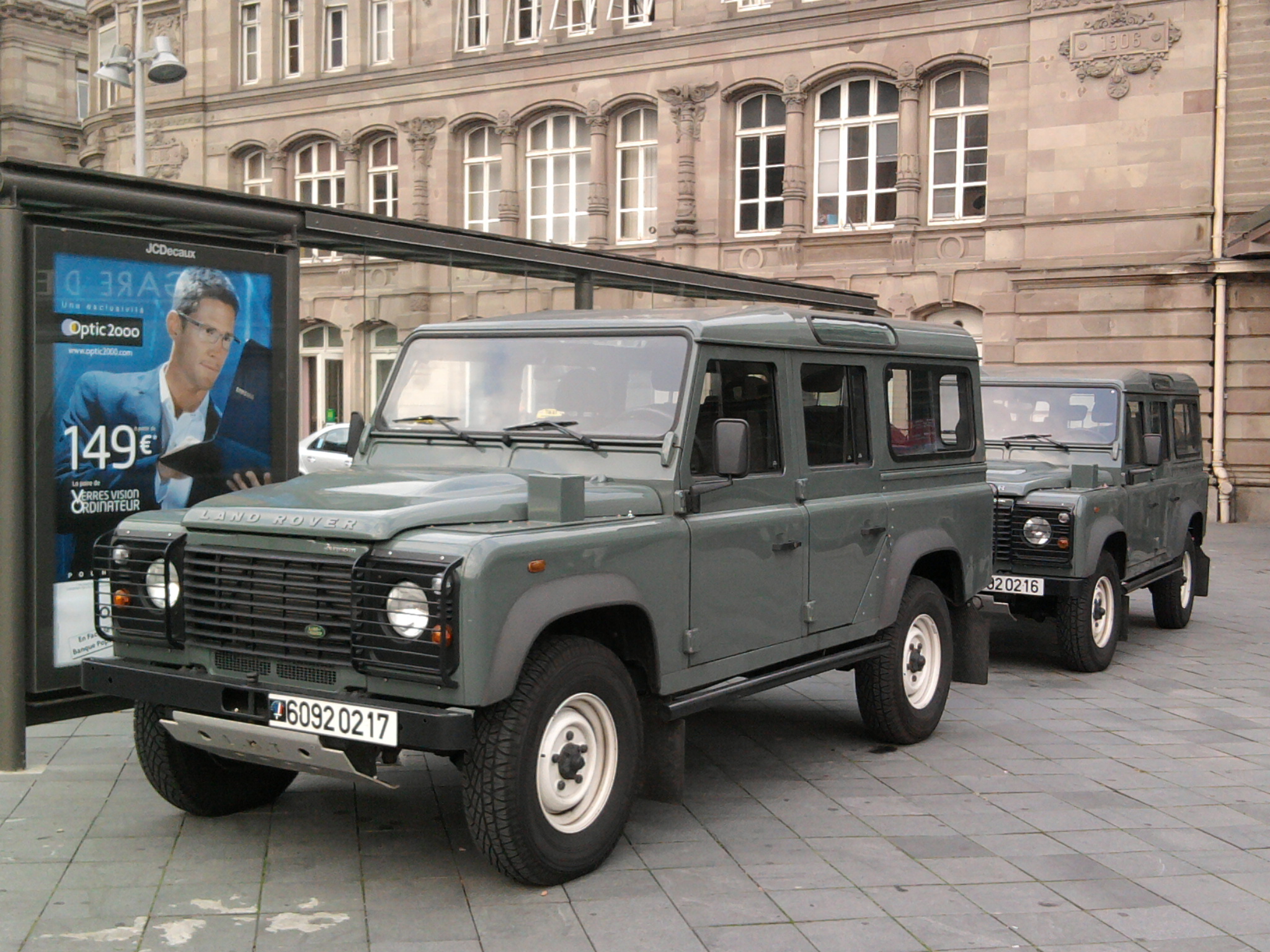 Two French Army Durisotti Defender 110 Station Wagons of the later 6092 series in sage green, place de la Gare, Strasbourg, October 2011 — registrations 6092 0217 and 6092 0216, with the post-2007 convex Puma bonnet