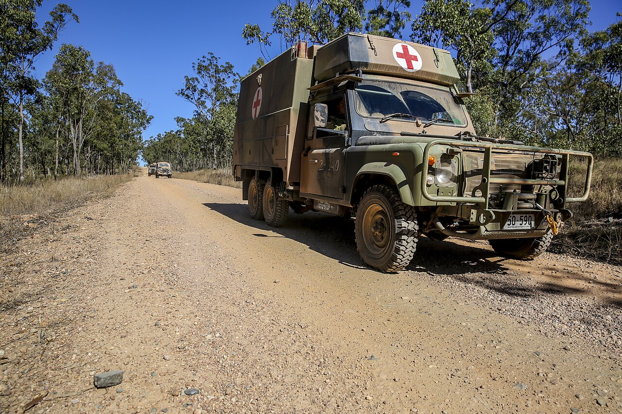 Australian Army Perentie 6x6 on patrol during Exercise Hamel, July 2014. No freely licensed photograph of the 26-vehicle crew cab could be found; this is the four-litter ambulance variant, which shares the crew cab's extended galvanised chassis, third axle, wide cab, bull bar and winch but not its four-door body.