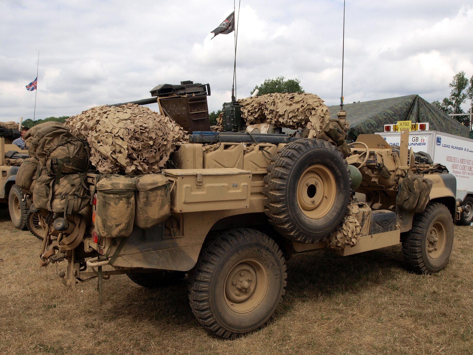 110 Pink Panther — Preserved SAS Land Rover 110 Desert Patrol Vehicle in desert sand, laden with jerrycans and camouflage netting