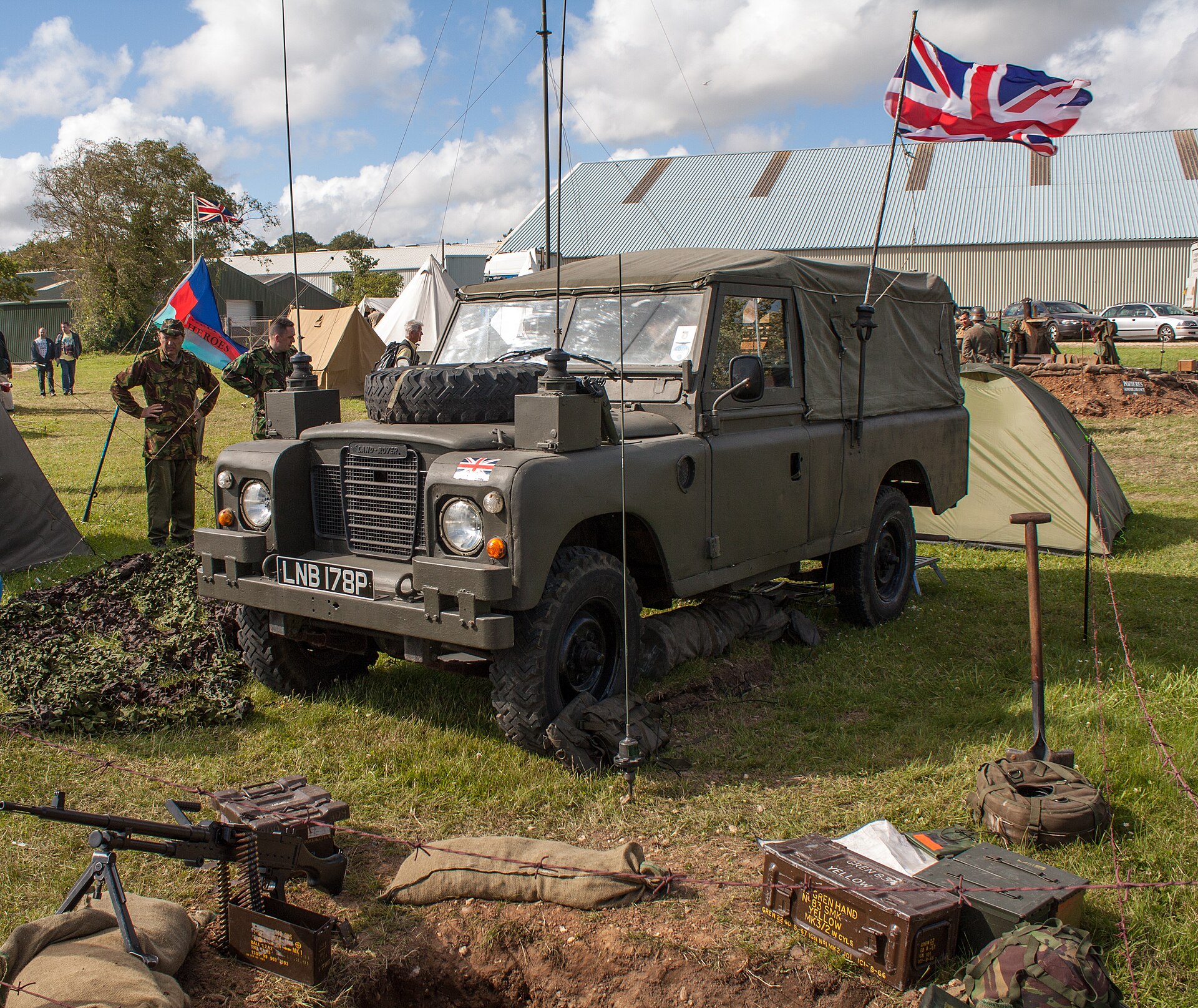 Series III 109″ · UK military — Preserved British Army Series III 109 FFR with canvas tilt and bonnet-mounted spare at a military vehicle display